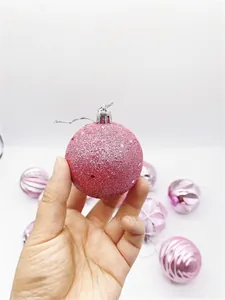 Pink Christmas ornament ball with glitter coating and decorative textured surface