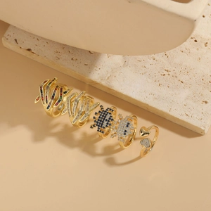 Close-up of gold geometric rings set with colorful gemstones and sparkling zircons