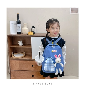 Detail of cute plush bunny on trendy blue toddler backpack with checkered zip pocket