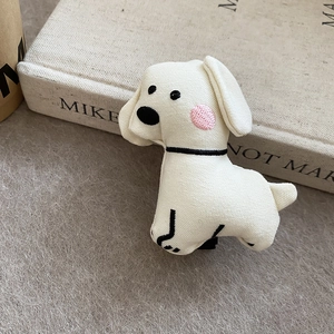 Detailed macro view of the cream white plush puppy hair clip with fabric texture