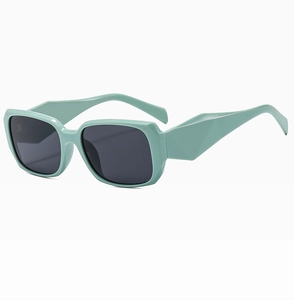 Detail of mint green square frame sunglasses with thick retro temples and grey lenses