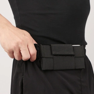 Detail of a black elastic sports waist bag with velcro closure worn by a runner