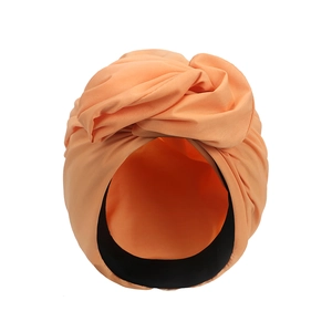 Detailansicht eines orangefarbenen Turban-Huts mit Knotendesign und elastischem Stoff