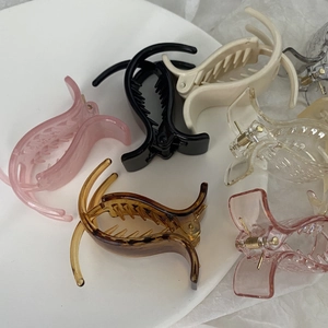 Detailed arrangement of colorful acrylic mini hair clips on a white minimalist plate