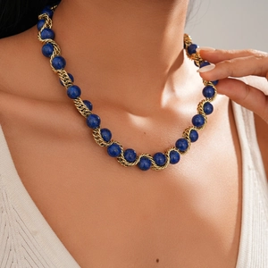 Dettaglio di collana vintage con perline di lapislazzuli blu e catena a corda dorata