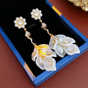 Detail of flower stud earrings with gold wavy bar, zircon accents and pearl petals