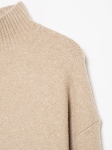 Gros plan d'un pull en maille kaki doux avec col montant et détails d'épaules