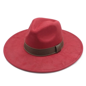 Detail of red wool felt fedora hat featuring a wide brim and dark brown decorative band