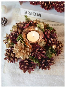 Detailed view of red Christmas pinecone wreath candle holder with golden baubles decoration