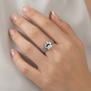Close-up of mesh pattern stainless steel ring with a black enamel cat paw detail