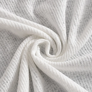 Close-up of soft white knitted fabric texture showing breathable woven pattern details