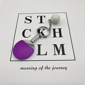 Detail of purple rubber texture on mini table tennis racket keychain with white ball