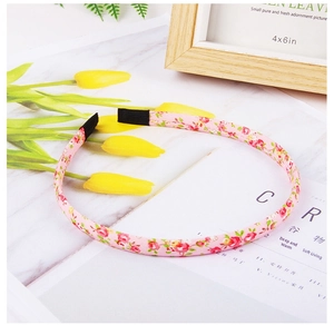 Detailed view of pink floral pattern fabric headband resting on a magazine with tulips