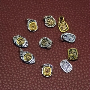 Silver and gold Tibetan style alloy pendants with tribal face and wheel relief on leather