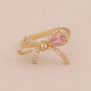 Détail d'une bague nœud dorée avec pierre rose poire et cristaux micro-pavés