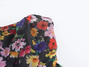 Close-up of sweet organza floral bubble dress with colorful flowers on black fabric