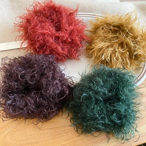 Detailed close-up of colorful plush faux fur scrunchies displayed on a white ceramic plate