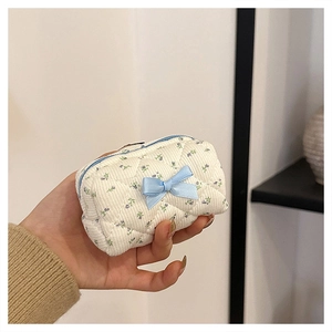 Close-up of quilted floral cotton pouch with blue flowers and a decorative bow