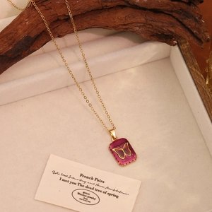 Detail shot of vintage purple heart butterfly pendant on gold chain in jewelry box