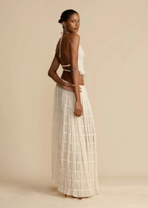 Detail of a chic cream halter neck top with a tiered maxi skirt and ruffled texture