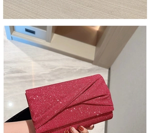 Pochette de soirée rouge à paillettes avec texture plissée et chaîne en gros plan
