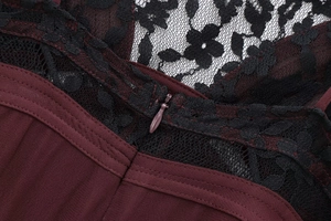 Close-up of invisible zipper and floral black lace detail on wine red dress back
