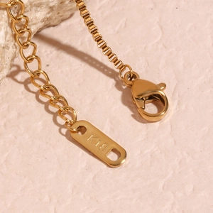 Detailed macro view of 18K gold-plated necklace lobster clasp and extension chain