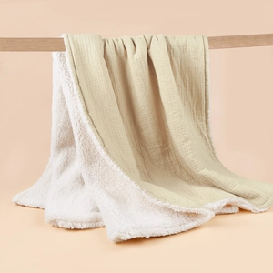 Close-up of double-layer muslin cotton blanket with thick white sherpa fleece lining