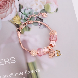 Rose gold beaded bracelet featuring pink crystals, enamel flowers and a heart pendant