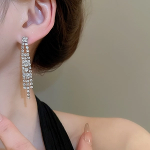 Gros plan de boucles d'oreilles de mariée avec pompons en zircone sur base argent