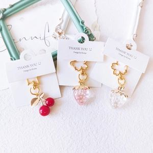 Charming iridescent strawberry and cherry keychains with star-shaped gold buckles