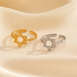Adjustable cutout star rings in gold and silver finish on elegant silk background