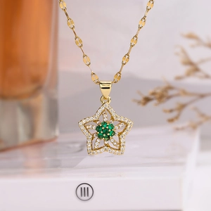 Elegant gold plated star necklace with green zircon flower pendant on marble base