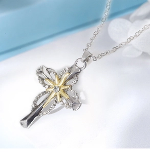 Detailed macro view of two-tone gold and silver cross pendant with sparkling rhinestones