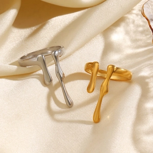 Minimalist gold and silver lava style open rings displayed on an elegant satin background
