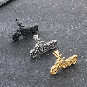 Dettaglio dei ciondoli a forma di moto in nero opaco, argento vintage e oro