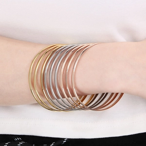 Detail of multi-layered 3.6mm stainless steel bangles in gold, silver, and rose gold