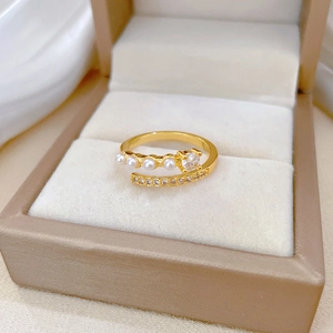 Detail of adjustable gold ring with pearls and sparkling cubic zirconia in jewelry box