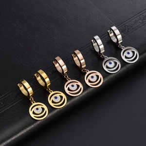 Detailed view of evil eye earrings in gold, rose gold and silver on black leather