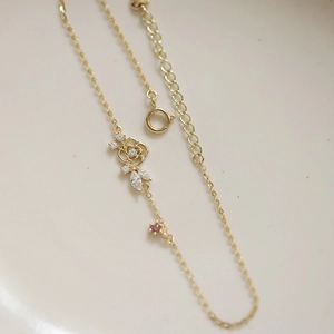 Macro shot of 14K gold-plated sterling silver bracelet with rose pendant and pink zircon