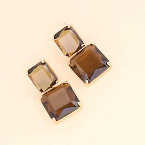 Detail of square brown crystal earrings with tiered geometric design in gold finish