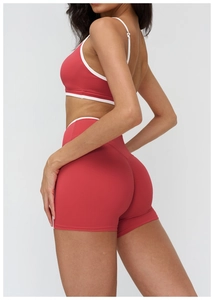 Detail of red yoga set with white trim, showing elastic quick-dry fabric and slim fit