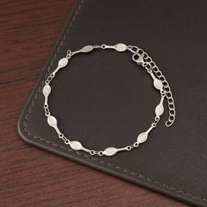 Detail view of silver badminton racket link bracelet on a dark textured background