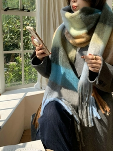 Detail of soft multi-color plaid cashmere scarf with thick braids and fringe tassels