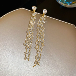 Close-up of 18k gold plated tassel earrings with heart-shaped crystal and cubic zirconia