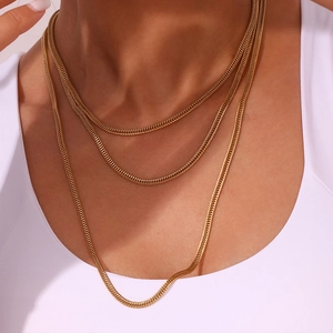 Three-layer gold foxtail chain necklace detail on model showing layered drape and texture