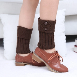 Close-up of dark brown knit leg warmers with diamond pattern and double button detail