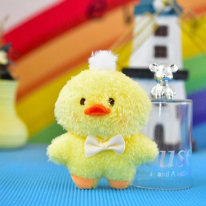 Vista dettagliata di un simpatico ciondolo pulcino in peluche giallo con fiocco bianco