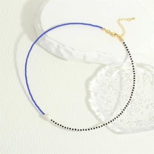 Detail of colorful glass beads necklace with irregular freshwater pearl and gold clasp