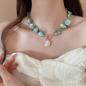 Detail of teal shell bead necklace with white pearl pendant and gold OT toggle clasp